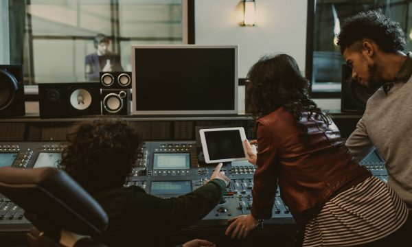 sound producers using tablet together at recording studio sound producers using tablet together at recording studio